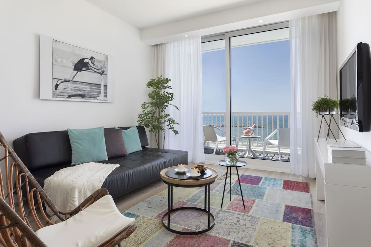 Apartment, 1 Bedroom, Sea View | Living room | 50-inch flat-screen TV with satellite channels, books