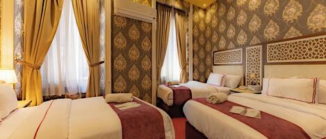 A hotel room with three beds, a large window with curtains, an air conditioning unit, and a decorative headboard.