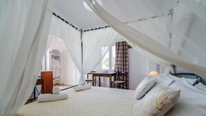A bedroom with a bed, a desk, and a chair. - Stavros Villas (Santorini)