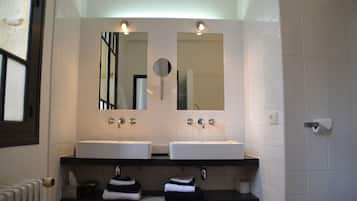 A bathroom with two sinks, a mirror, and a towel rack.