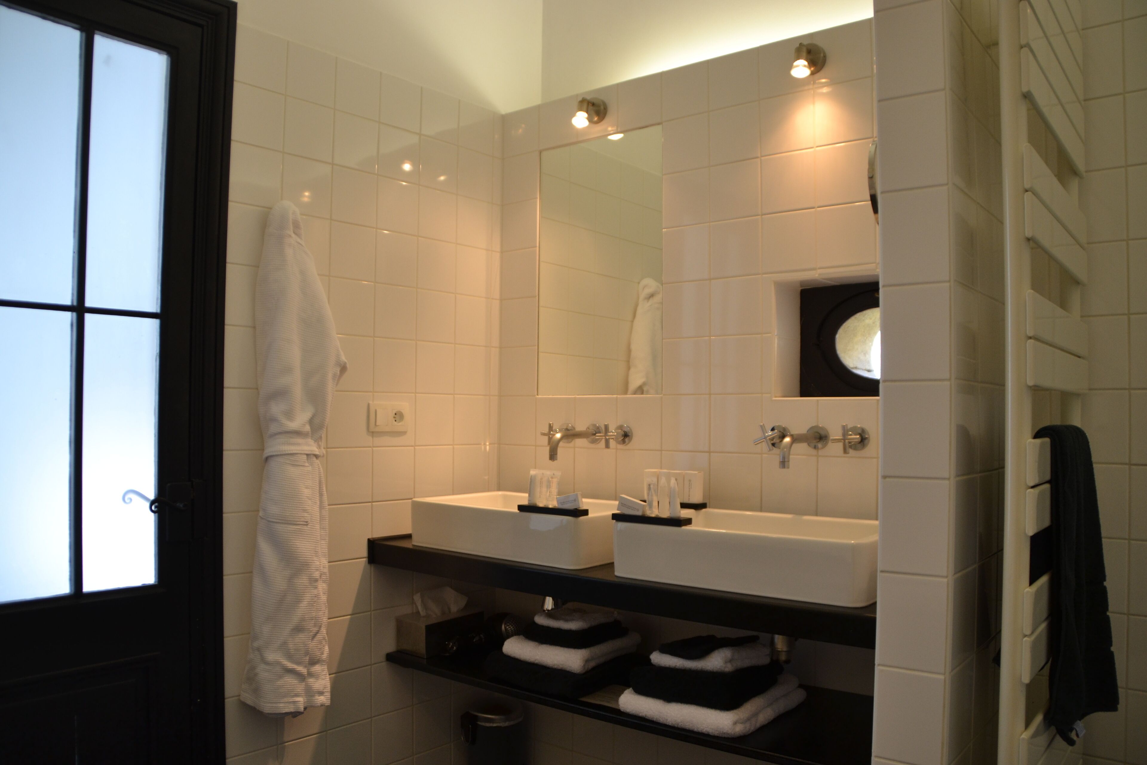 A bathroom with two sinks, a mirror, and a towel rack.