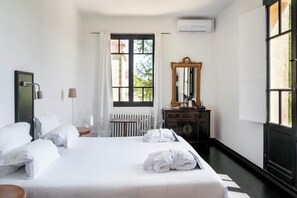 Een hotelkamer met een bed, een dressoir, een spiegel en een raam met gordijnen.
