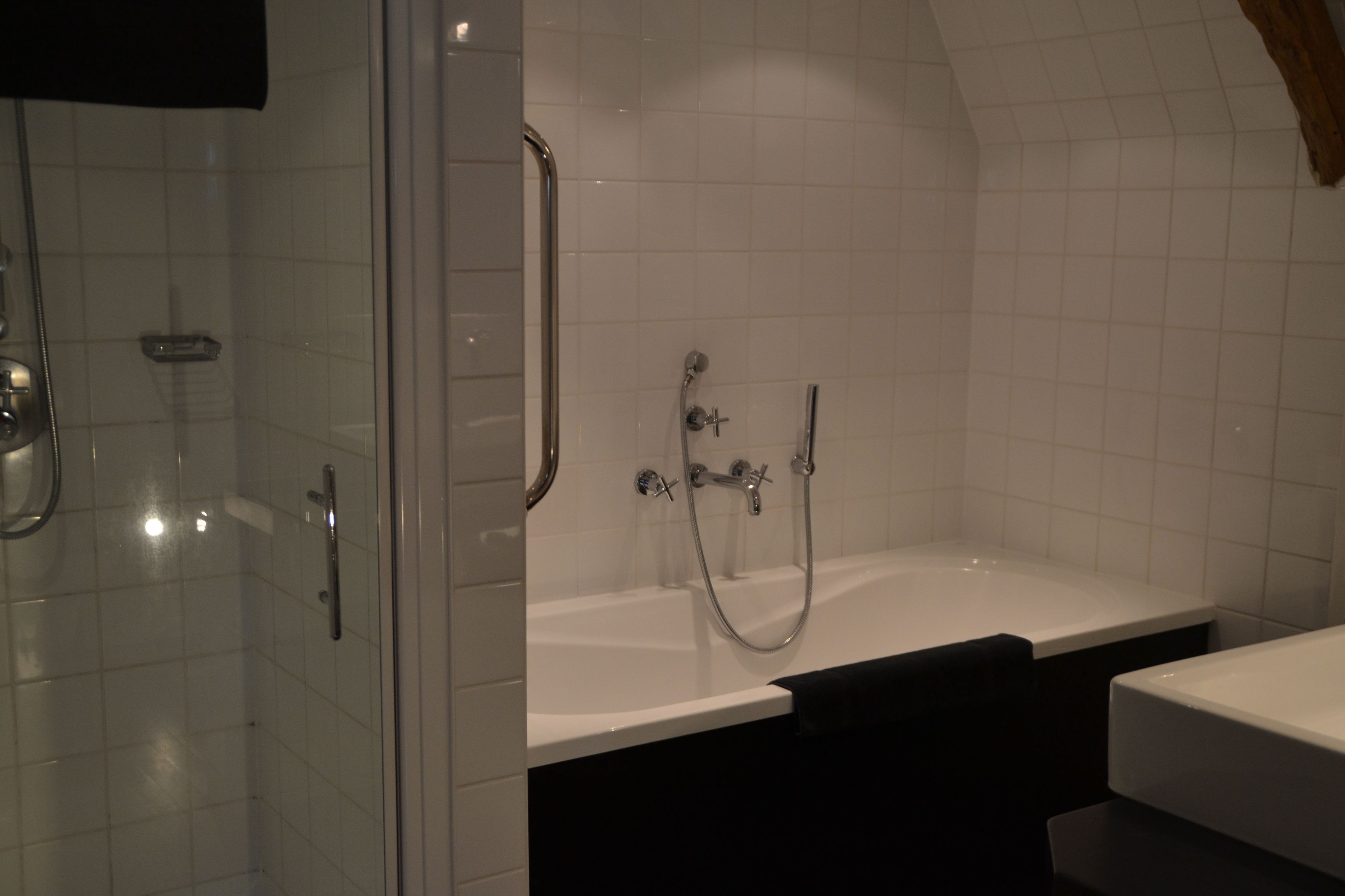 Une salle de bain moderne dotée d’une douche à parois de verre, d’une baignoire sur pied et d’un espace lavabo séparé.