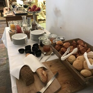 Een buffet met diverse soorten eten, zoals brood, gebak en toevoegingen.