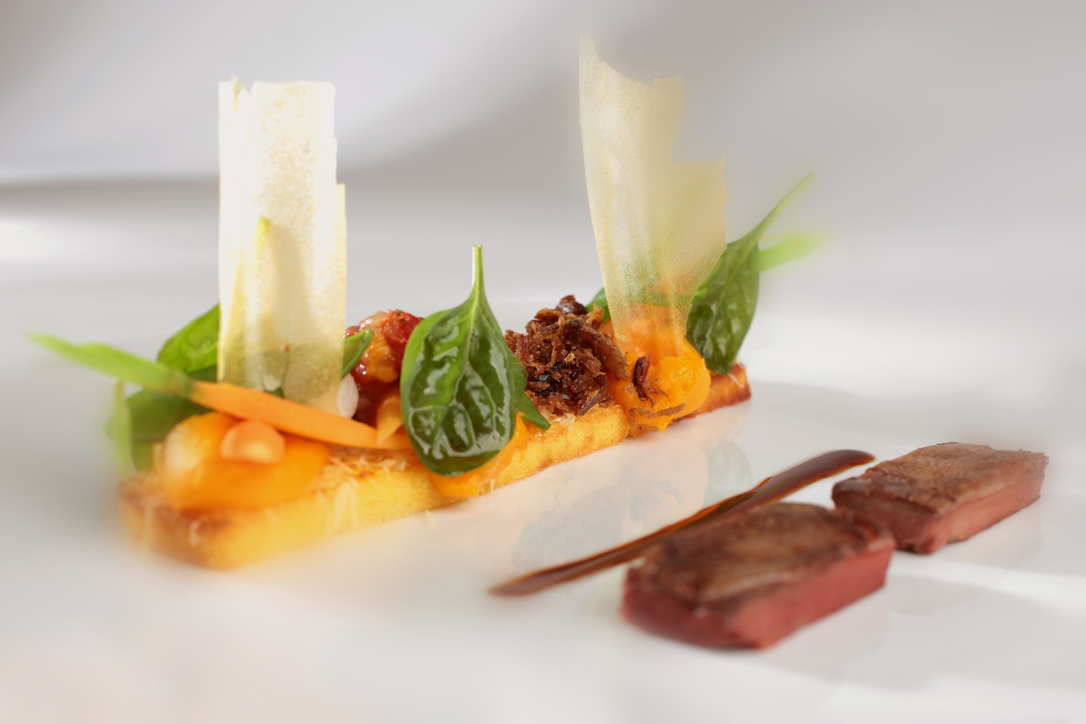 A dish with various ingredients and a knife on a white plate.