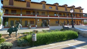 A yellow building with balconies and red flowers.