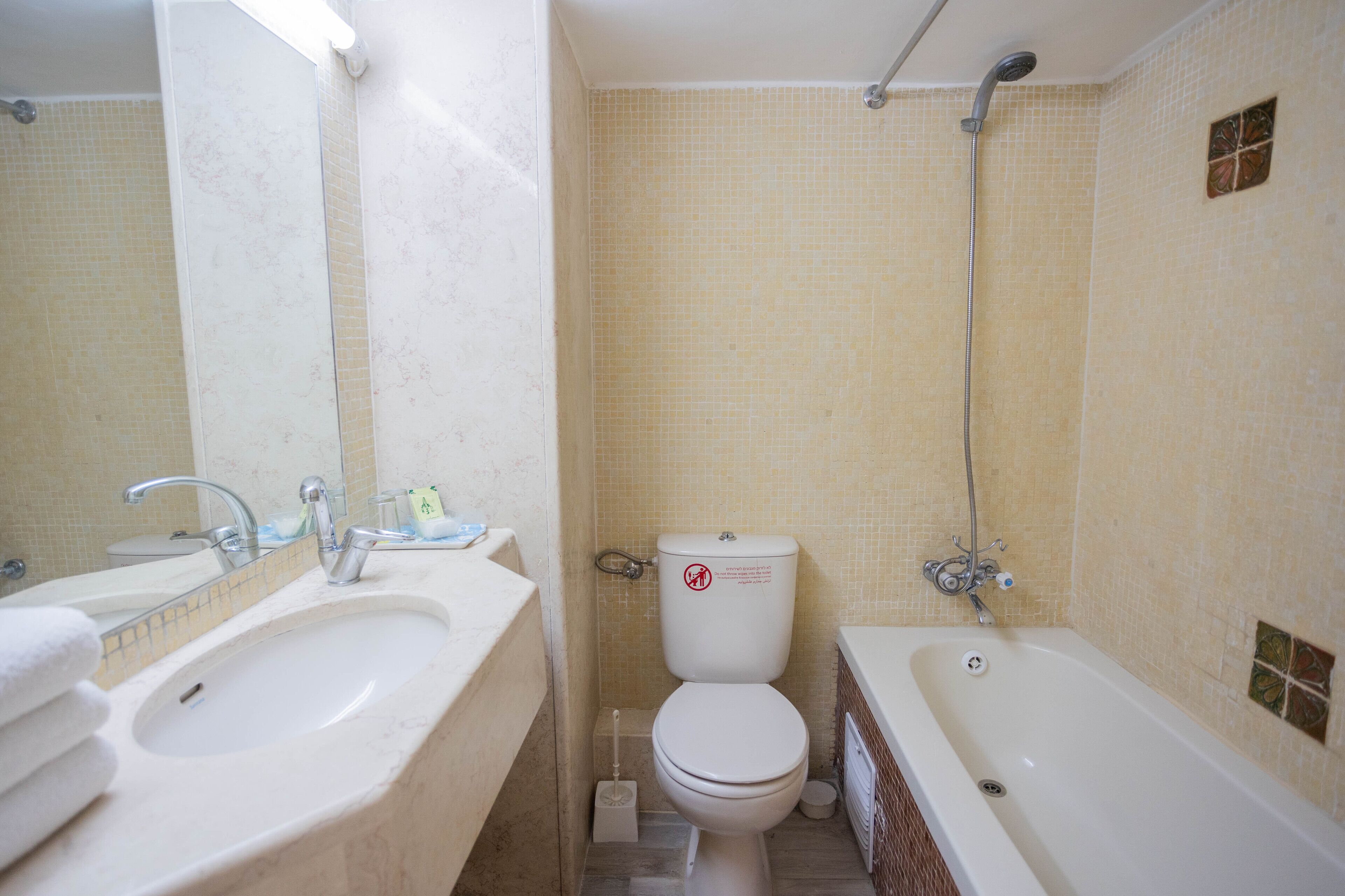 Un baño con lavamanos, inodoro y bañera.