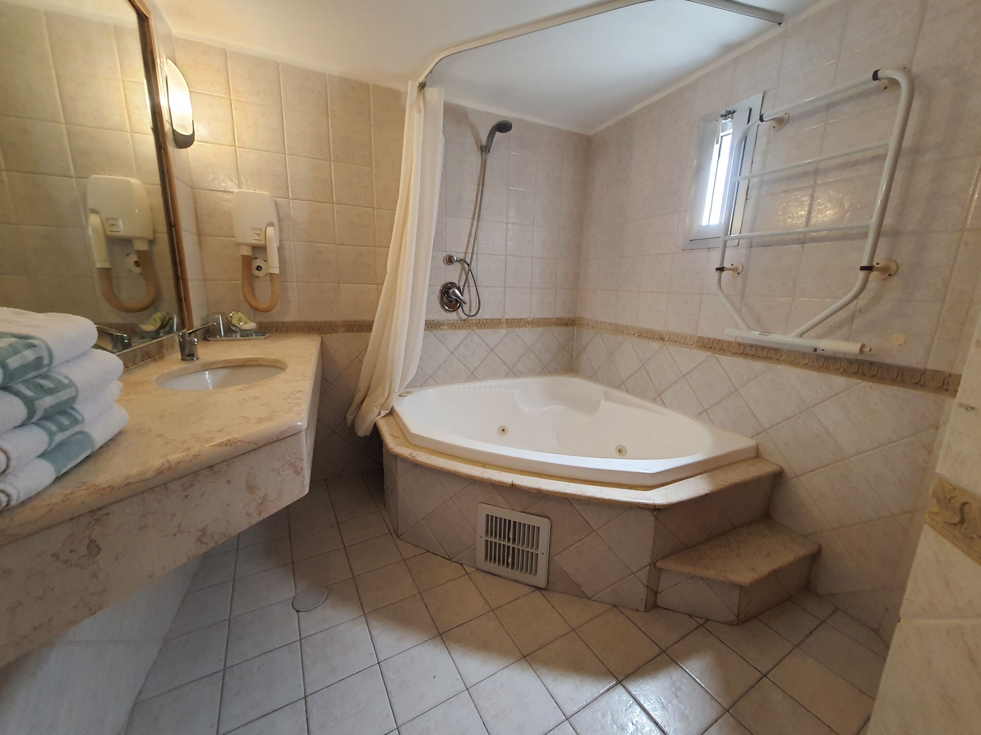 Un baño con bañera, lavabo y ducha.