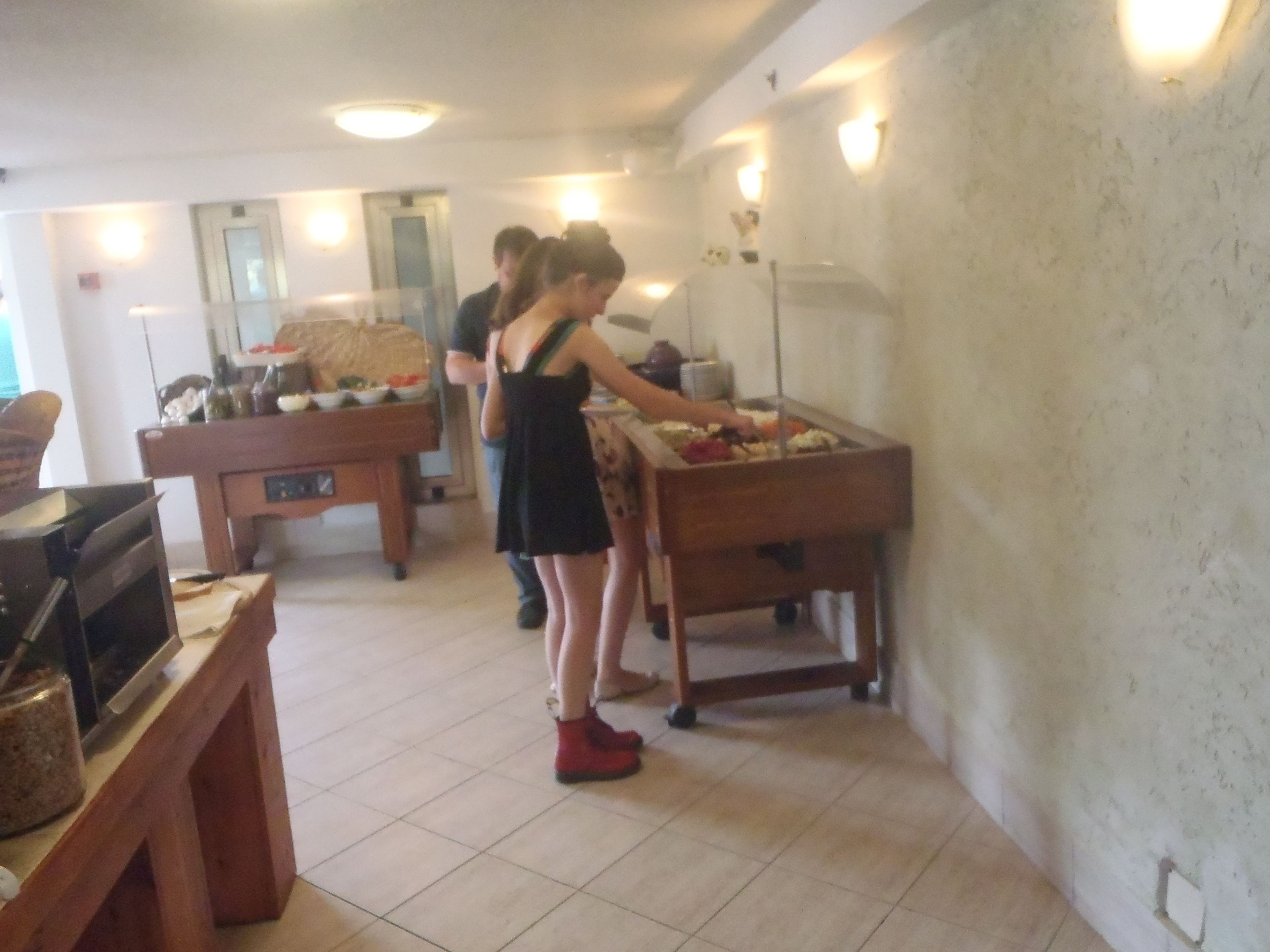 A room with a pool table, a buffet table, and a television.