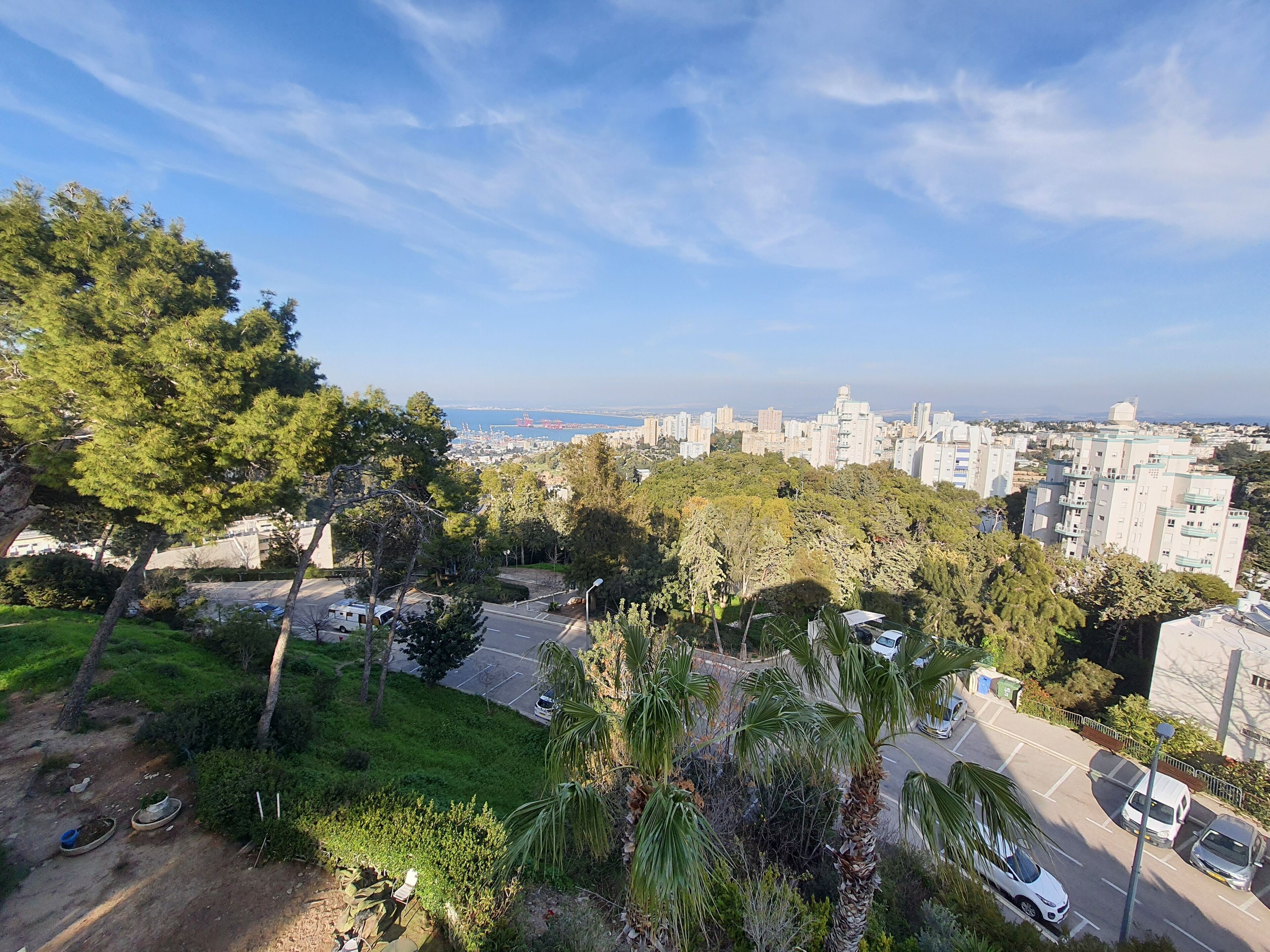 A cityscape with a view of buildings, trees, and a road.