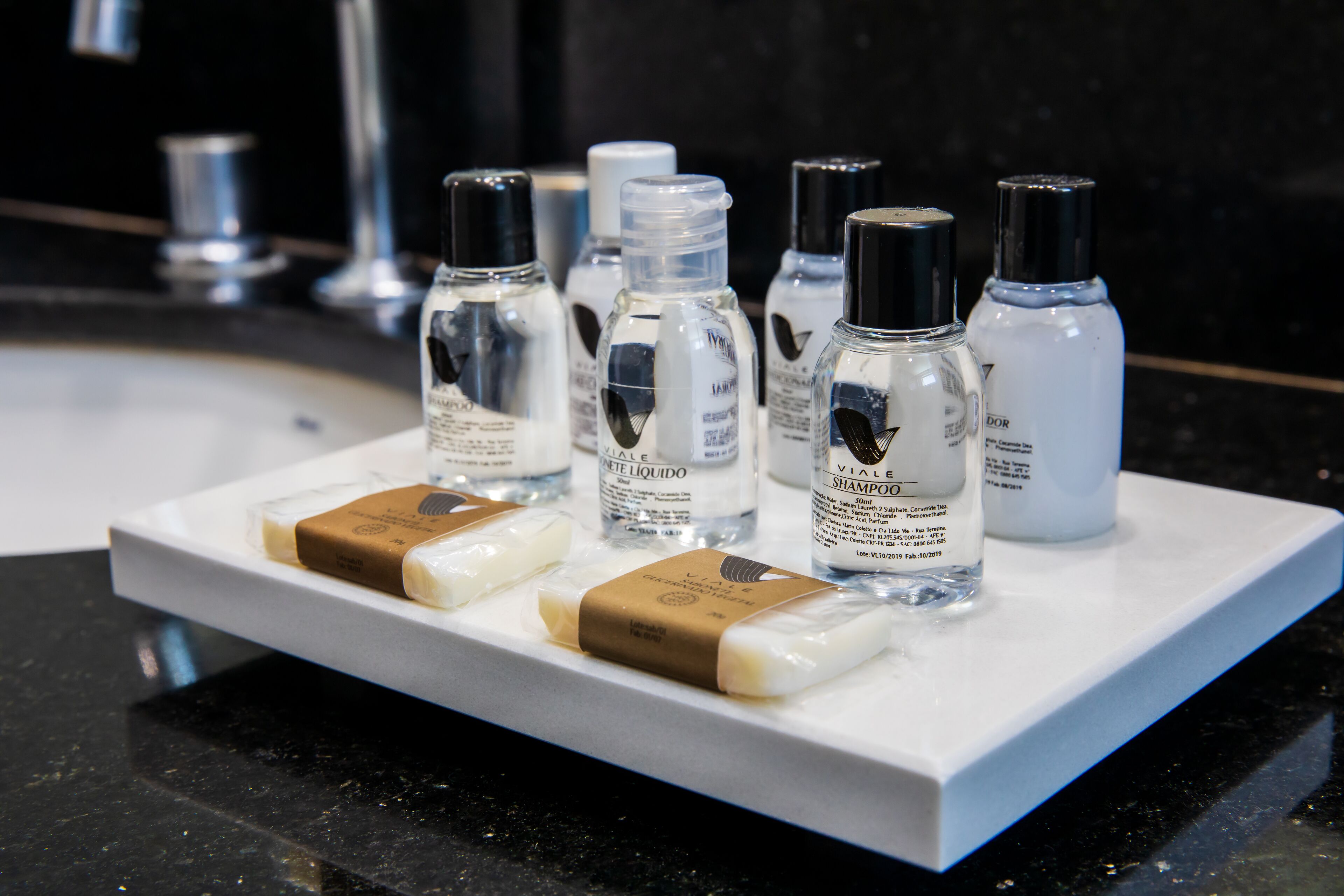 A display of toiletries including bottles and bars of soap on a white shelf.