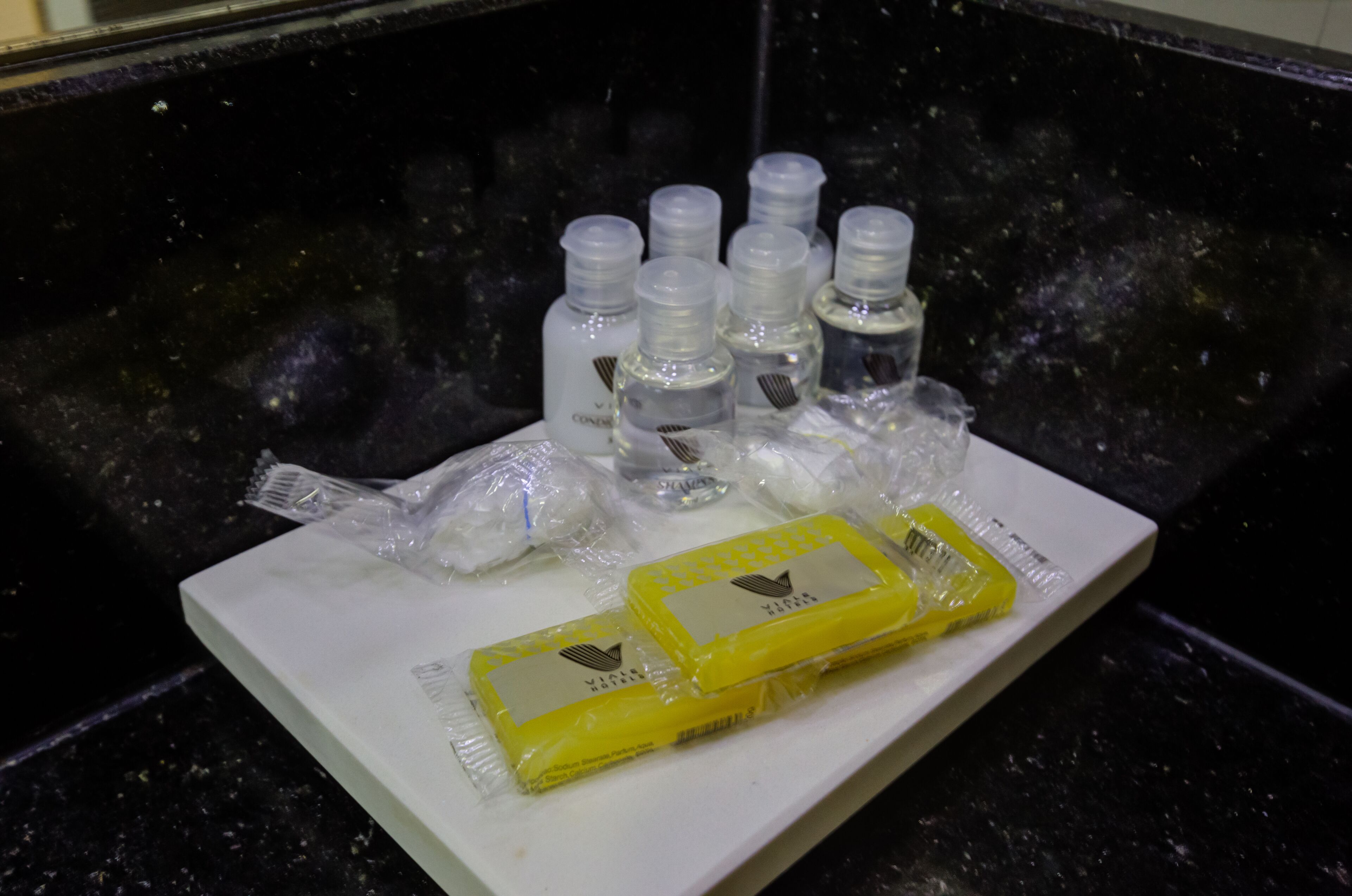 A tray with several small bottles and two yellow bars on a white surface.