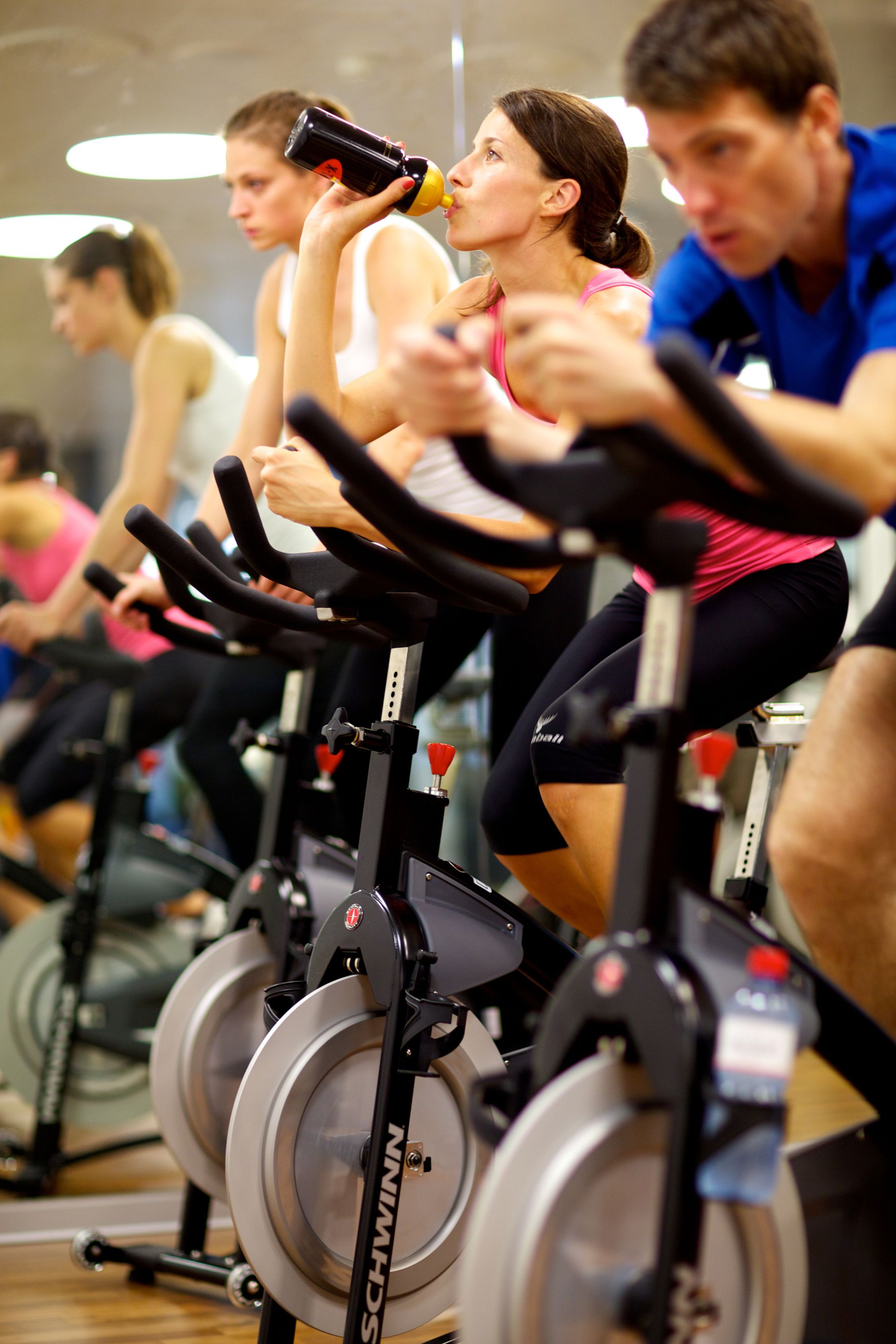 Un gruppo di persone che si allena su cyclette in palestra.