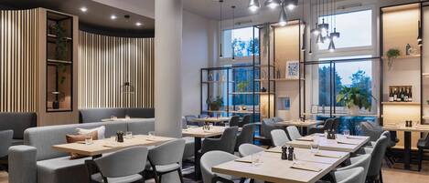 A modern restaurant with high tables and chairs, wooden paneling, and large windows.