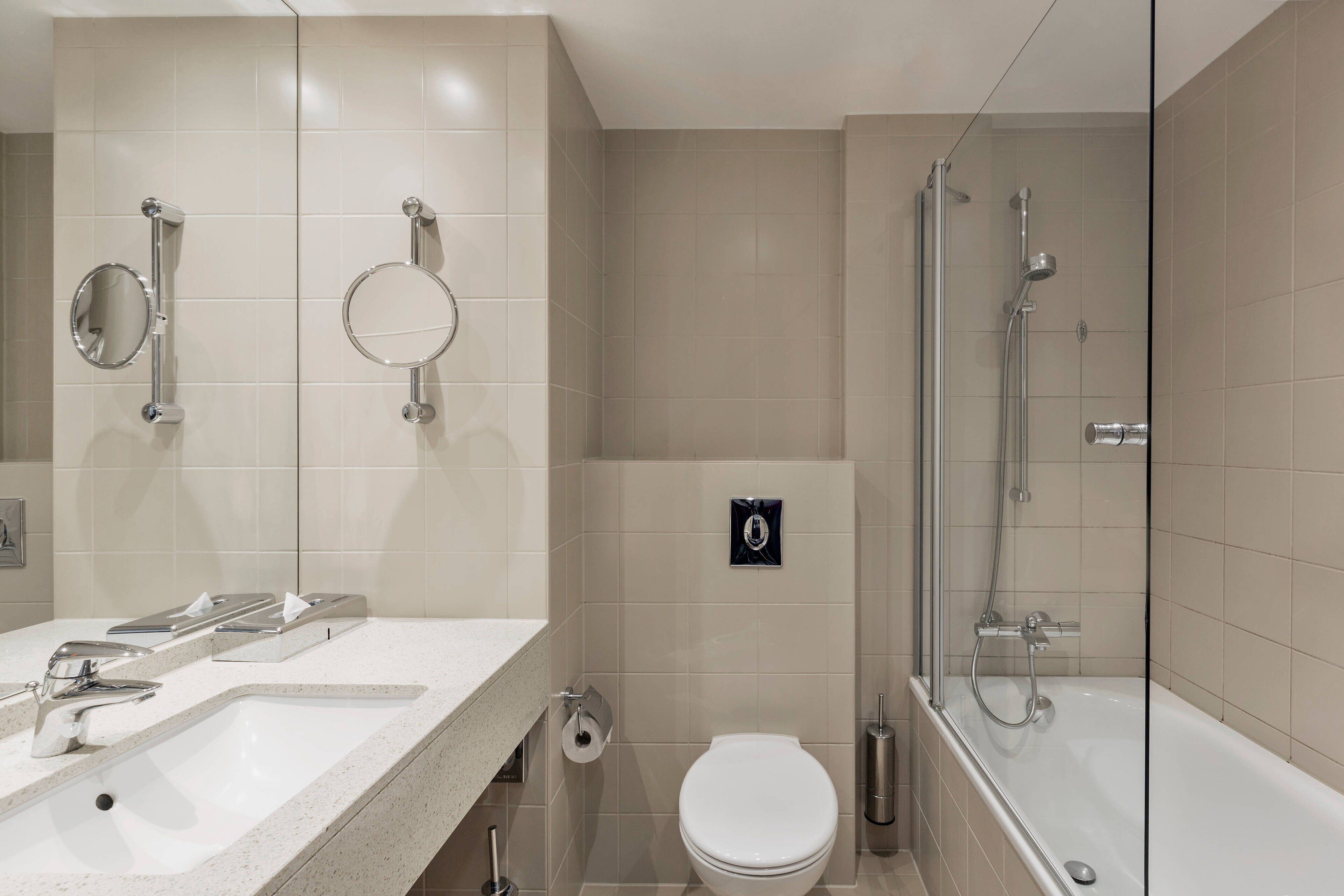 Une salle de bain moderne équipée d’un lavabo, de toilettes et d’une douche.
