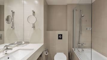Une salle de bain moderne équipée d’un lavabo, de toilettes et d’une douche.