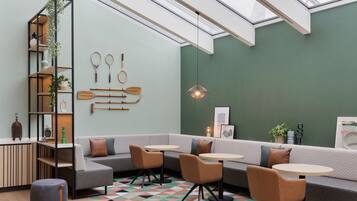 A modern interior with a sectional sofa, round tables, and a geometric patterned floor.