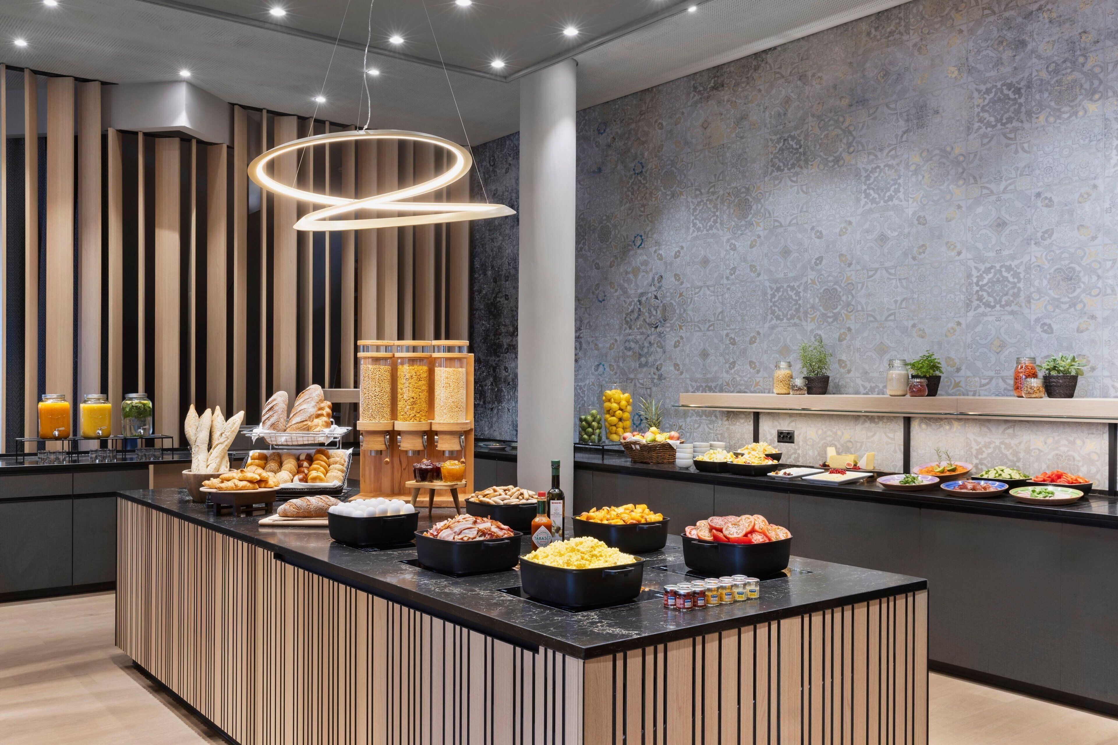 A buffet with various food items and a modern interior design.
