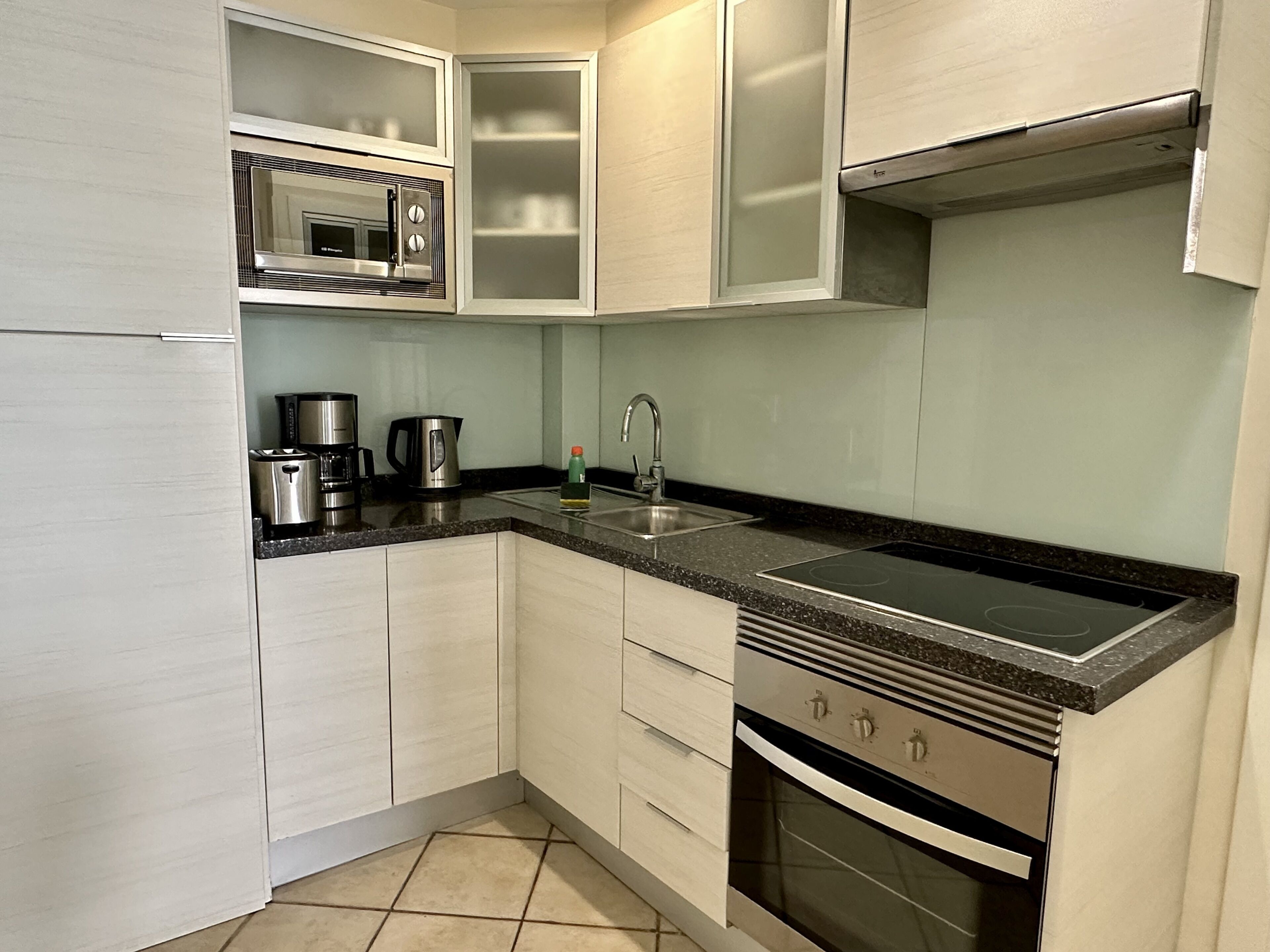 A modern kitchen with a built-in microwave, stove, and sink.