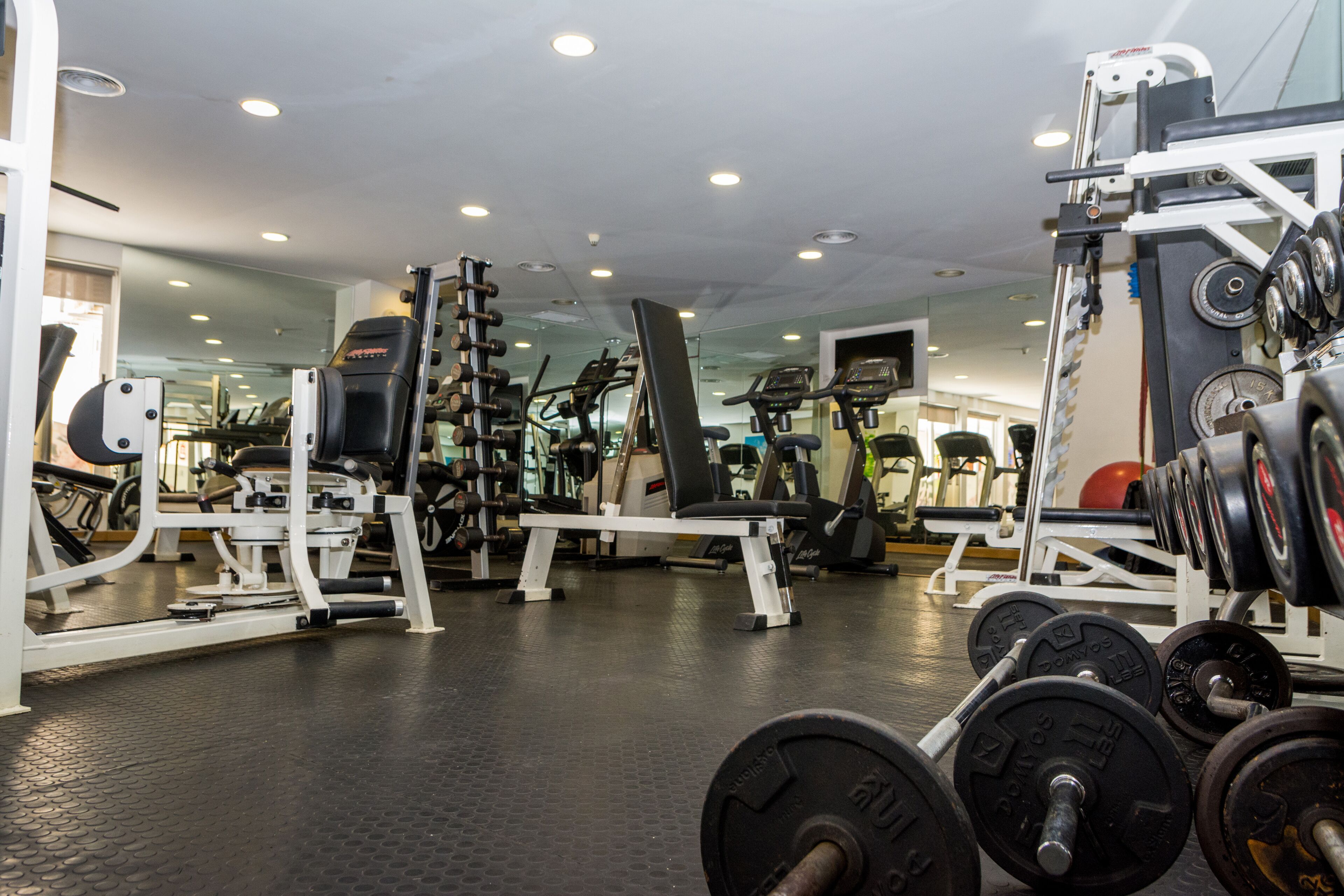Une salle de sport équipée de divers appareils d’entraînement, notamment des machines à poids et des poids libres.