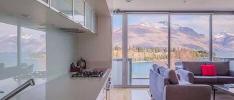 A modern kitchen with a large window overlooking a mountainous landscape.