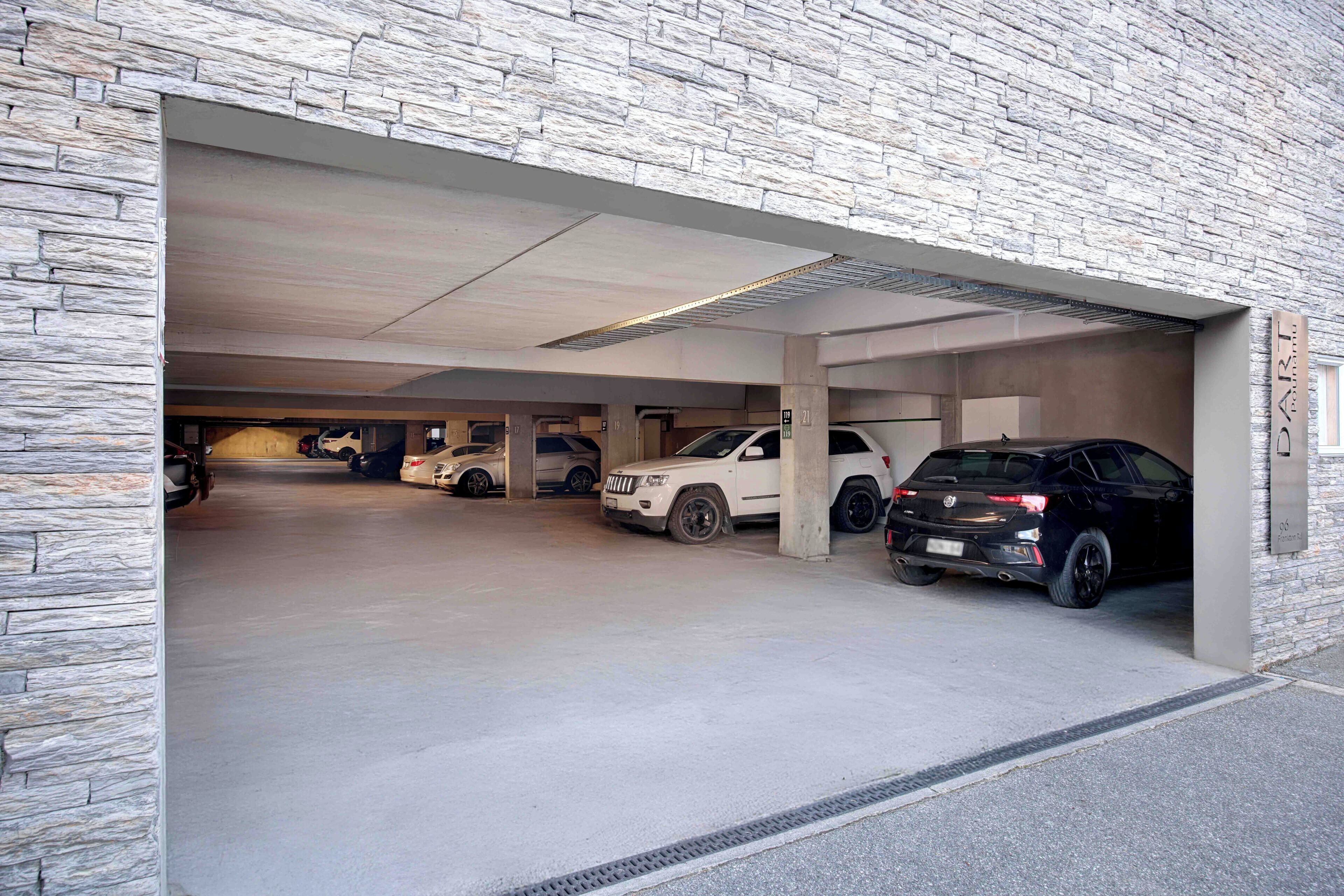 A multi-level parking garage with stone walls and concrete floors.