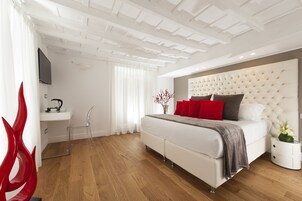 Ein modernes Schlafzimmer mit einem großen Bett, einem Nachttisch, einem Fernseher und einem roten Dekoschaukel.