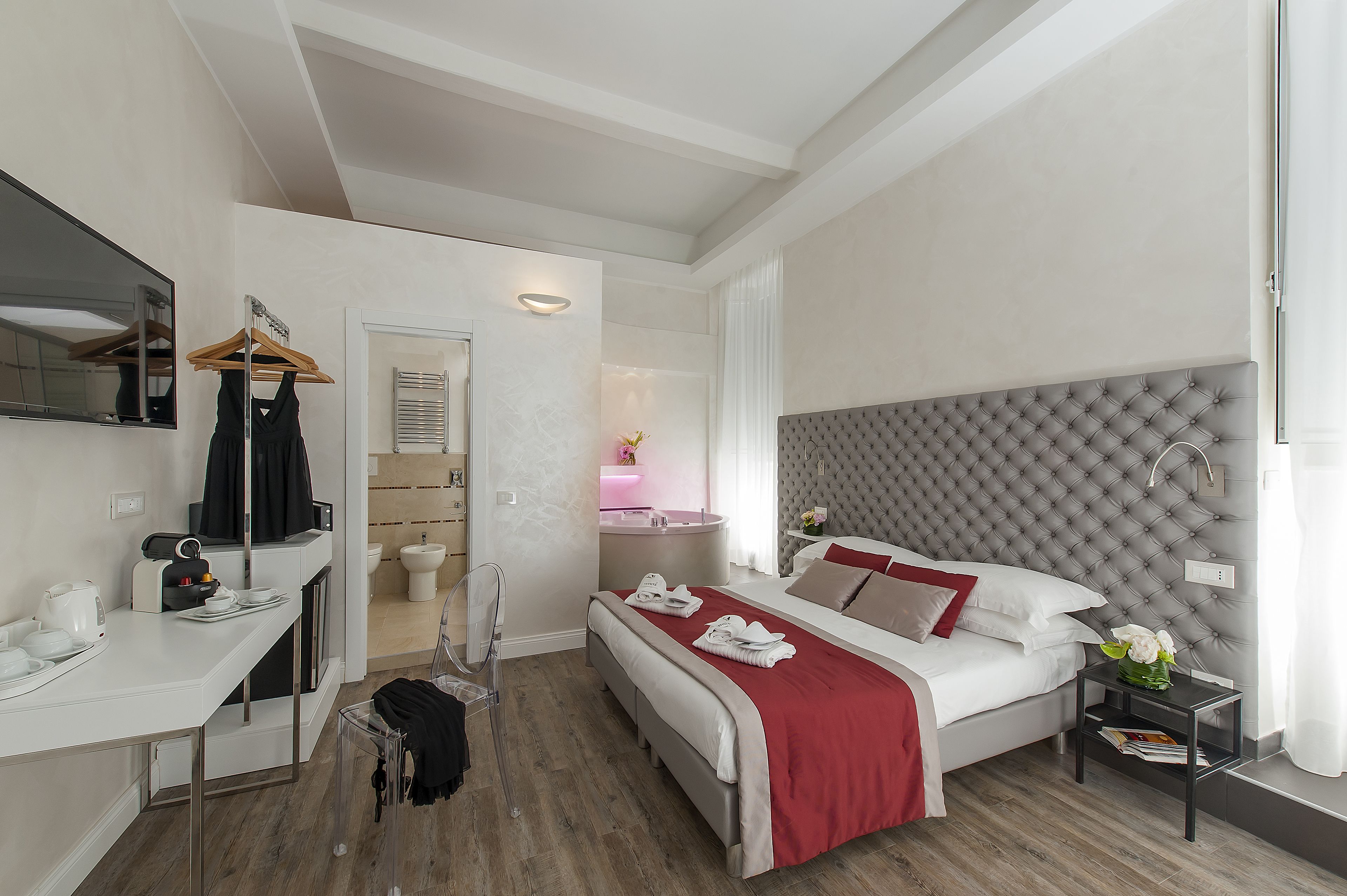 Una habitación de hotel moderna con una cama, una mesita de noche y un escritorio con una silla.