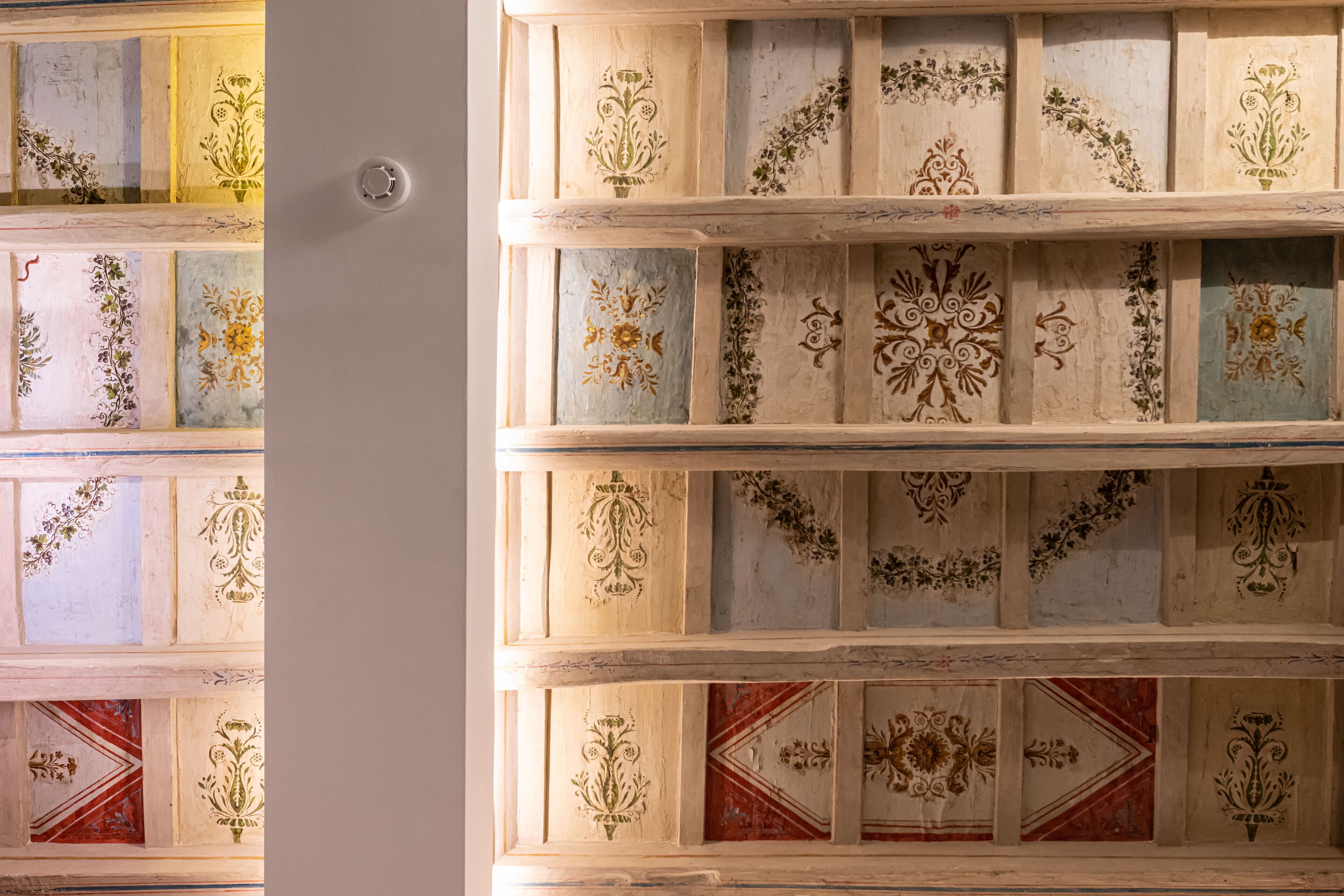 Techo con paneles decorativos que presentan motivos florales y geométricos.