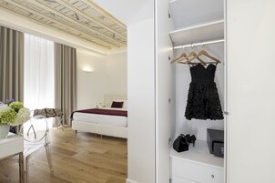 Et moderne hotelværelse med seng, garderobeskab og skrivebord med stol.