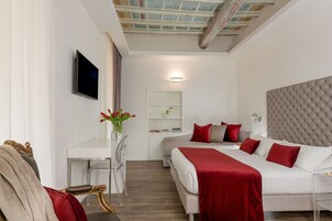 A modern hotel room with a large bed, a desk, and a television.