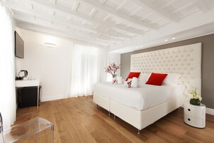 Una camera da letto moderna con un letto grande, un comodino, una scrivania e una TV montata a parete.