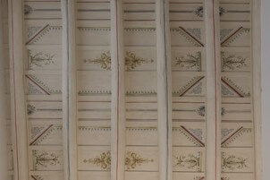 A ceiling with decorative panels and intricate designs.