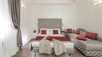 Um quarto com cama, sofá, mesa de cabeceira e criado-mudo.