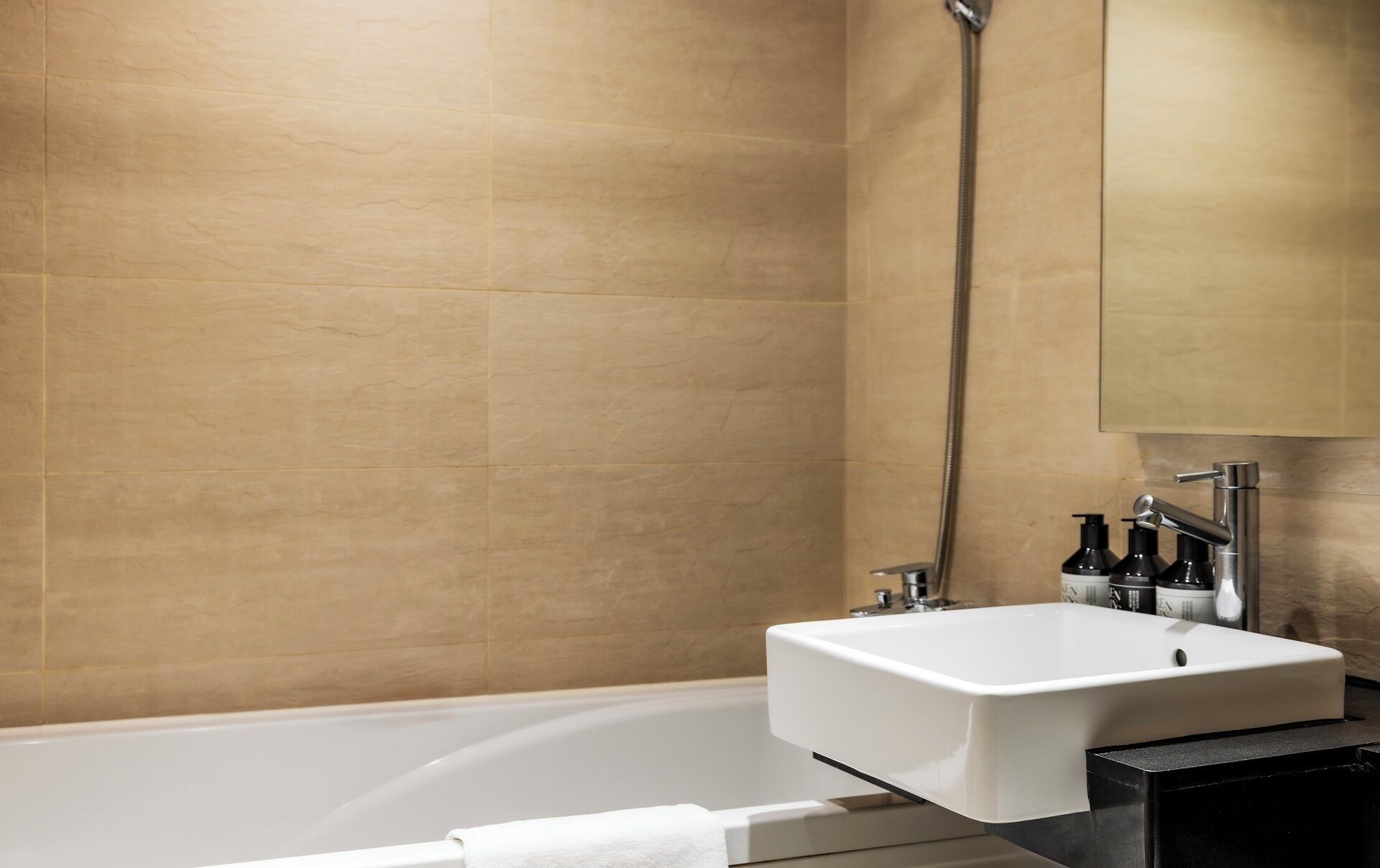 A modern bathroom with a bathtub, a sink, and a shower.