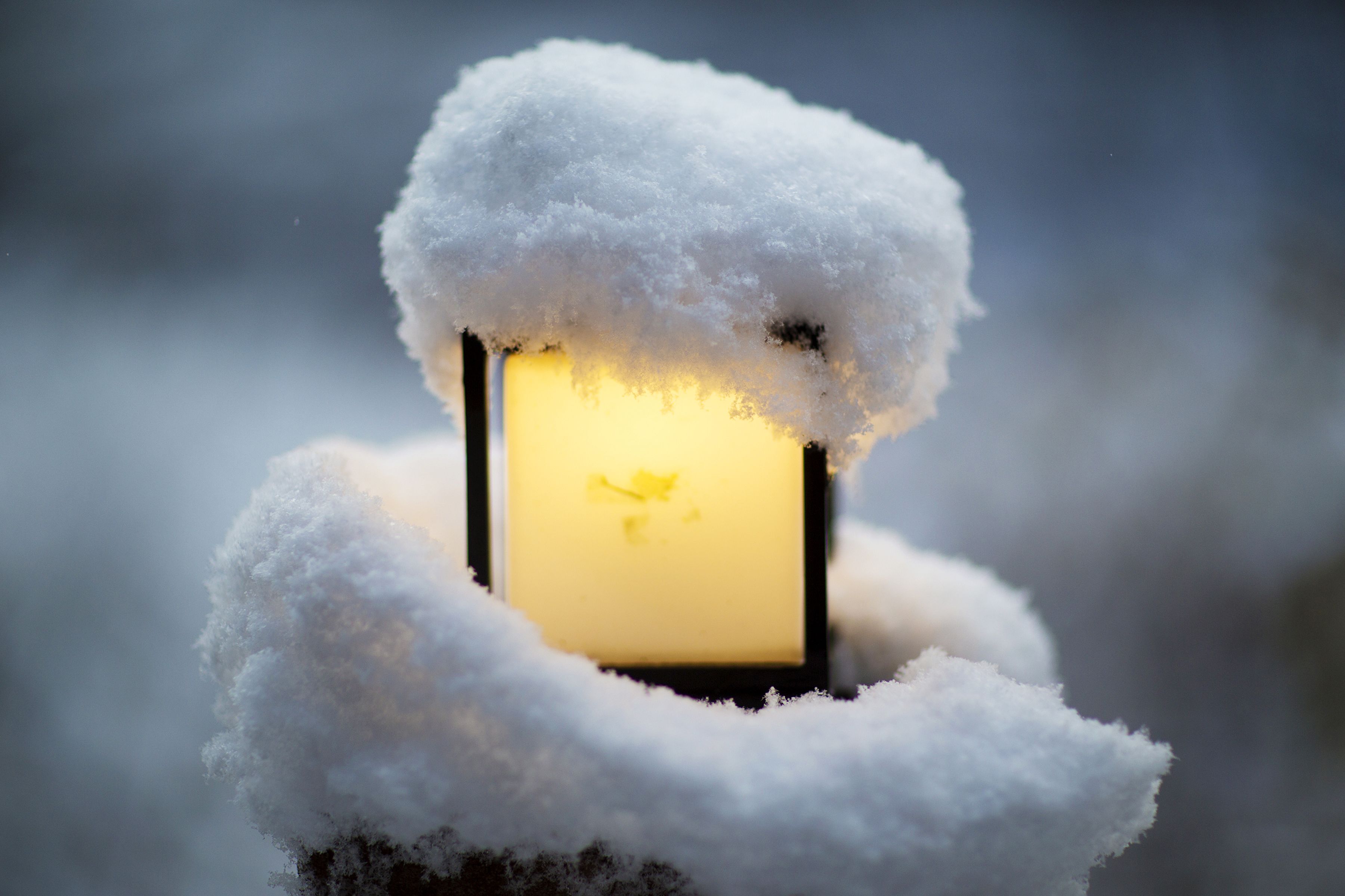 A snow-covered lantern emitting a warm light.