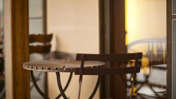 A close-up of a wooden chair with a metal frame, positioned next to a table with a round top and a metal base.