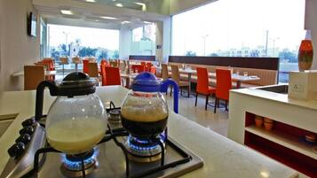 Una cocina con estufa a gas y cafetera.