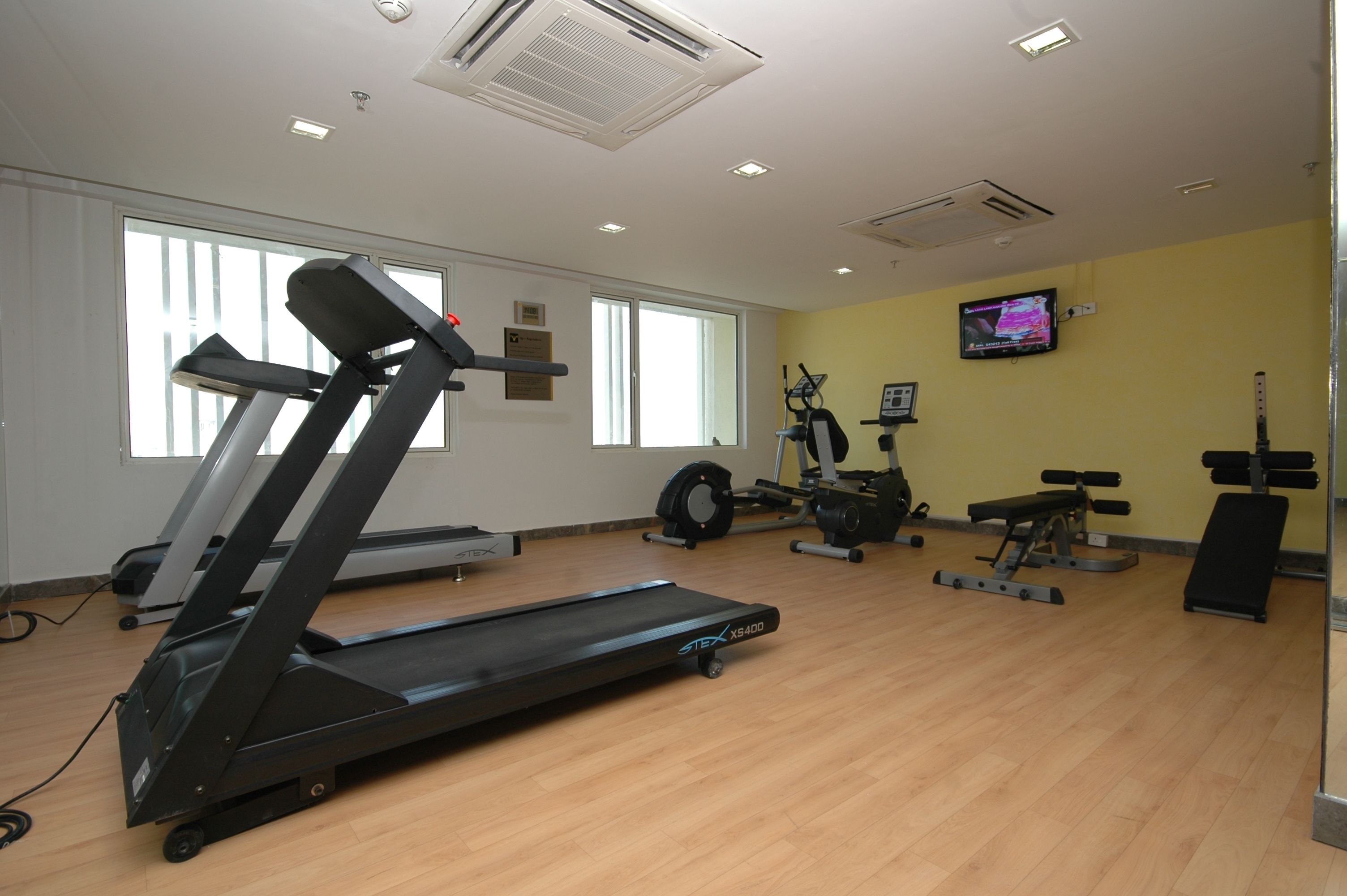 A gym with treadmills, a stationary bike, and weight equipment.