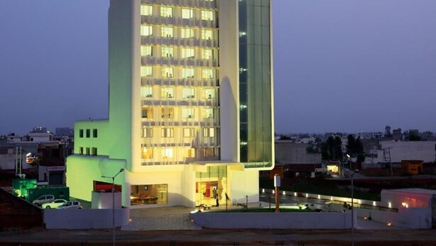 A modern hotel with a prominent 'REVS' sign, multiple floors, and a glass facade. - Keys Select by Lemon Tree Hotels, Ludhiana (Ludhiana)