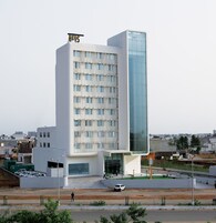 Un hotel moderno con fachada de vidrio destacada y techo plano.