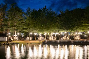 A lakeside campsite with tents, a dock, and a reflection of lights on the water. - Kensington Hotel Pyeongchang (Pyeongchang)