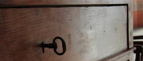 A wooden dresser with a keyhole drawer.