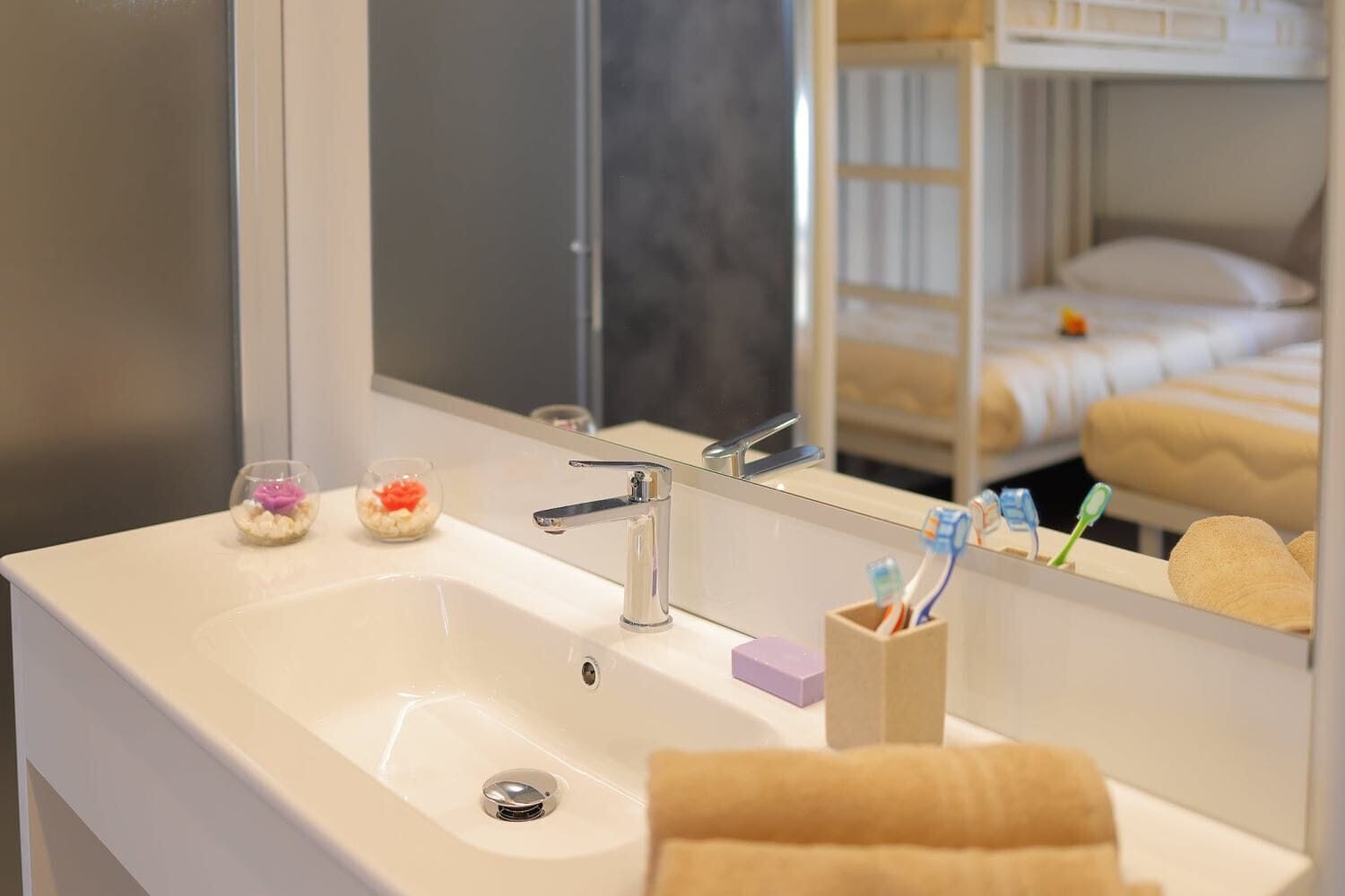 Un baño con lavabo, espejo y artículos de aseo.