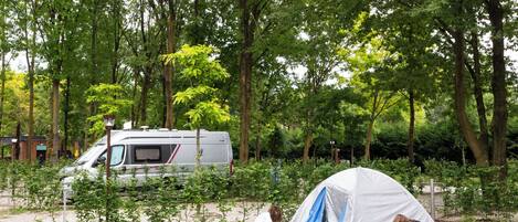 Un camping con una tienda de campaña y una autocaravana.