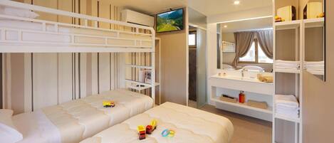 A hotel room with two beds, a TV, a bathroom with a mirror, and a wardrobe.