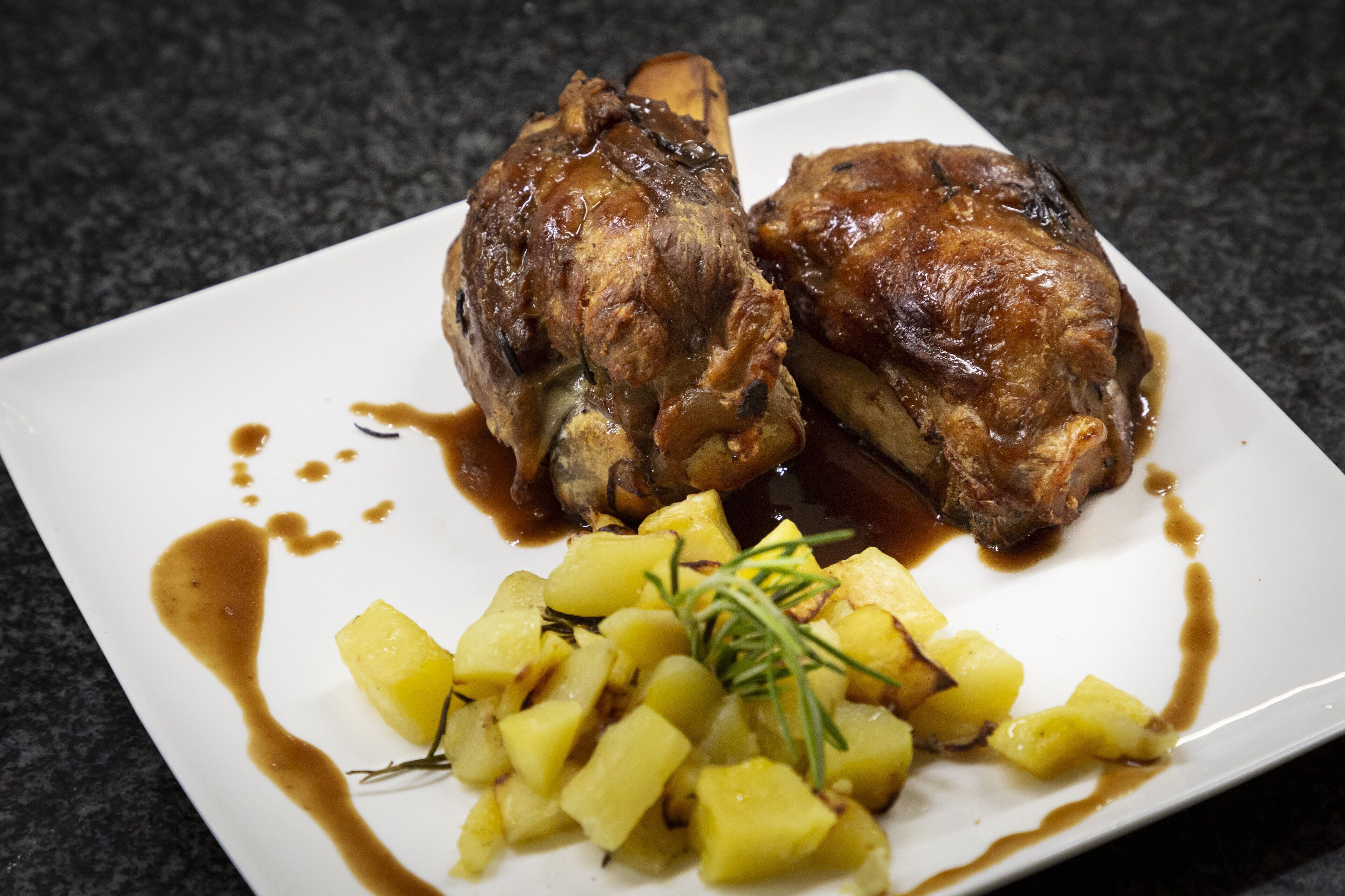 A plate with roasted chicken and potatoes.