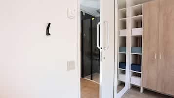 Une pièce avec une armoire blanche, une porte en verre et un tapis beige.