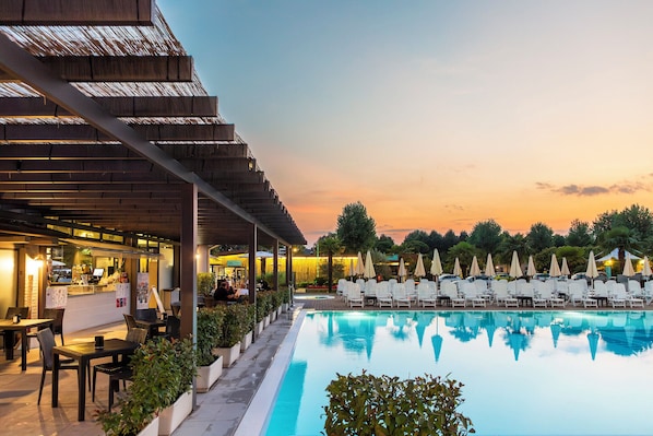 Una piscina al aire libre de temporada, sombrillas