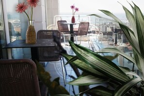 A balcony with wicker chairs, a glass table, and a vase with flowers. - Sembol Hotel (Istanbul)